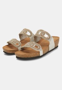 Sandali bianchi con soletta in sughero testurizzato, doppie cinghie con dettagli intricati in perline e suola in gomma marrone.