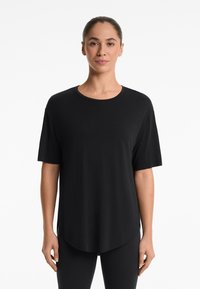 Black short-sleeve t-shirt with a round neckline, made of soft fabric. Features a curved hemline and side slits for added comfort.