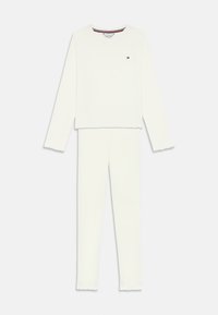 Hvid langærmet top og matchende bukser i loungestil med lille logo på brystet og subtile ribbede kanter på ærmerne og buksebenene.