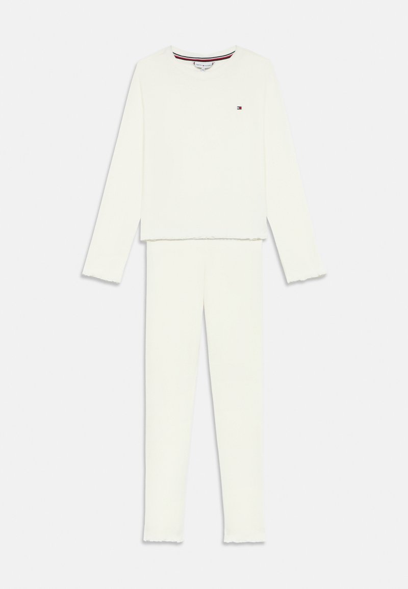 Hosszú ujjú fehér felső és hozzá illő nadrág melegítő szett, kis logóval a mellrészen és diszkrét bordázott szélekkel az ujjakon és a nadrág szárán.