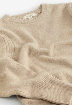 Beige stickad tröja i mjuk ullblandning, med rundad halsringning, ribbade ärmslut och sidodetaljer med en något fluffig textur.