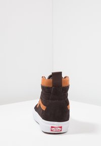 Brauner Wildleder-Sneaker mit hohem Schaft, einem orangefarbenen Akzentstreifen, weißer Gummisohle und verstärkter Fersenschlaufe. Markenlogo an der Ferse.
