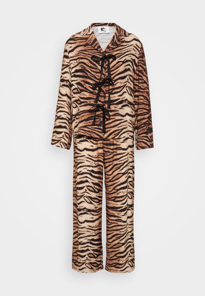 Tiger-mønster loungewear laget av myk tøy, med V-hals, lange ermer og tre svarte band foran. Løse bukser.