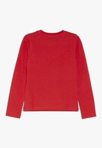 Long-sleeve red t-shirt made of soft fabric with a round neckline and straight hem. No patterns or graphics; minimal stitching detail.