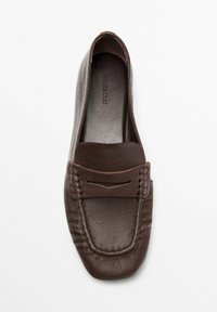 Brown leather loafers with a textured surface, a rounded toe, stitched detailing, and a decorative accent across the vamp.