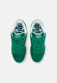 Baskets en daim vert avec un col matelassé, des lacets verts épais et des accents blancs. Semelle intérieure à motif damier avec la marque « mtn ». Semelle en caoutchouc.