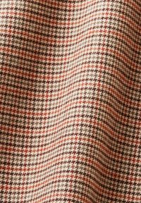 Tissu pied-de-poule marron, beige et rouille avec un motif à petits carreaux, montrant la texture et des plis doux.