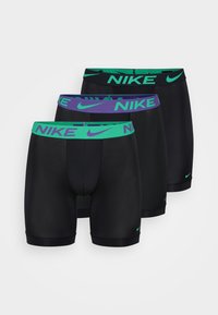 Fekete sportnadrág zöld és lila Nike márkájú derékpántokkal; sima anyag, testhezálló kialakítással; három pár látható.