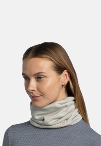 Light gray neck gaiter made of soft fabric, featuring a smooth texture and a branded tag. Worn loosely around the neck.