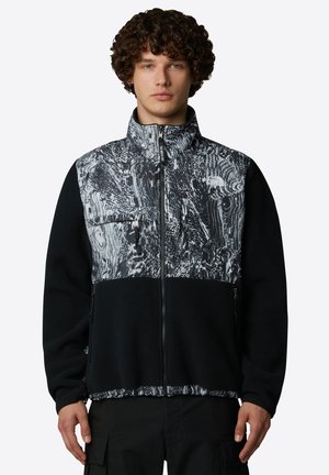 Fleecejacke mit schwarzem Körper und einer strukturierten, einfarbigen gemusterten Brust. Merkmale sind ein hoher Kragen, Reißverschlusstaschen und ein durchgehender Frontreißverschluss.