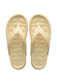 Béžové sandále s textúrovanou podrážkou, s dizajnom remienka v tvare V. Mäkký, flexibilný materiál a minimálne logo na boku.