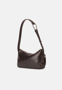 Tmavě hnědá kožená taška přes rameno s nastavitelným popruhem a horním zipem, zobrazena na jednobarevném světlém pozadí.