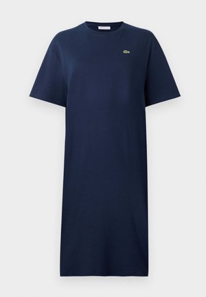 Robe t-shirt en coton bleu marine avec des manches courtes, col rond et un petit logo vert sur la poitrine. Coupe droite, longueur genou.