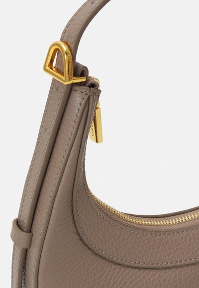Sac à main en cuir gris clair avec une finition texturée. Il dispose d'une fermeture éclair et d'accents matériels en ton doré, mettant en avant un design incurvé et une bandoulière robuste.