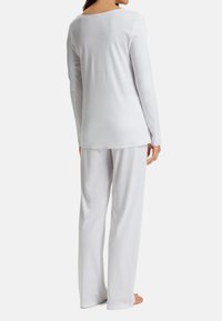 Set di maglietta a maniche lunghe e pantaloni bianchi, realizzato in tessuto morbido, caratterizzato da una vestibilità comoda e un design semplice, senza motivi o accenti visibili.
