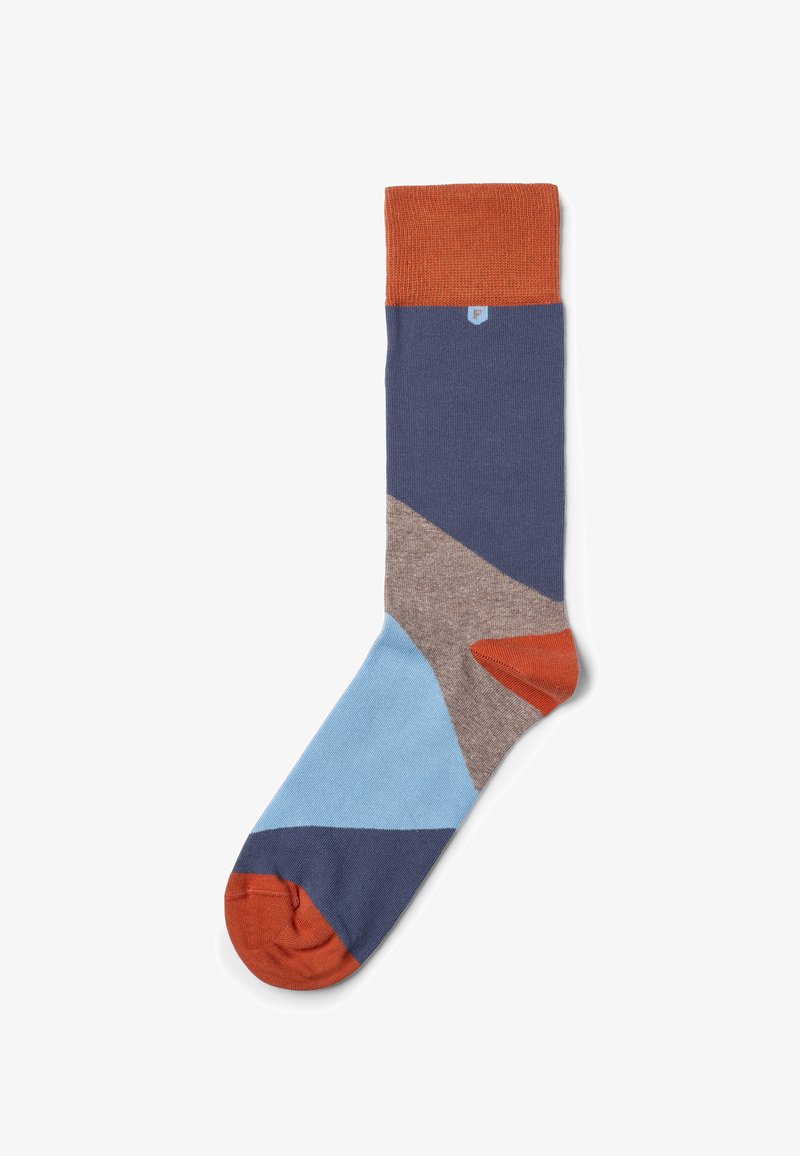 Flerfarvet strømpe med forskellige geometriske former i blå, marineblå, brun og orange, med en ribbet orange kant øverst.