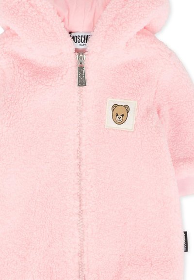 Jumpsuit en polaire rose pour bébé avec capuche, dotée d'une fermeture éclair à l'avant, d'un patch logo ours et d'une texture douce. Les poignets sont d'une couleur unie contrastante.
