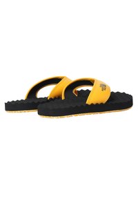 Sorte gummiflip-flops med gule stropper, der har en tekstureret fodseng og et zigzag-mønster på sålen. Brandlogoet er trykt på stroppen.