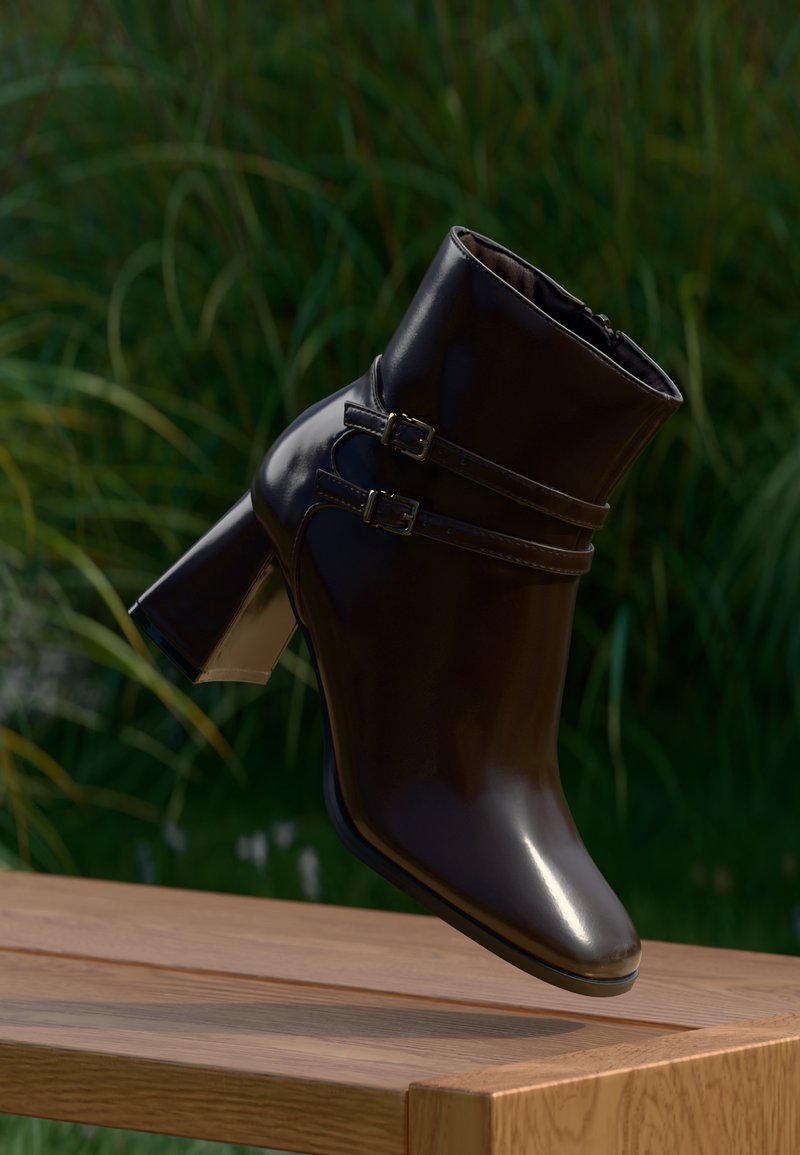 Botín negro con un acabado brillante, tacón cuadrado y dos hebillas decorativas. El diseño presenta una textura suave y una punta estilizada.