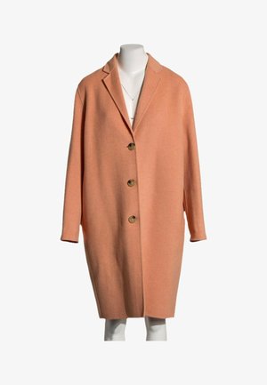 Long manteau en laine couleur pêche avec trois boutons et col à revers présenté sur un torse de mannequin blanc.