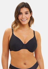 Soutien-gorge noir rembourré avec bord blanc, tissu lisse, bretelles ajustables et décolleté plongeant. Comprend un anneau pour un meilleur maintien.