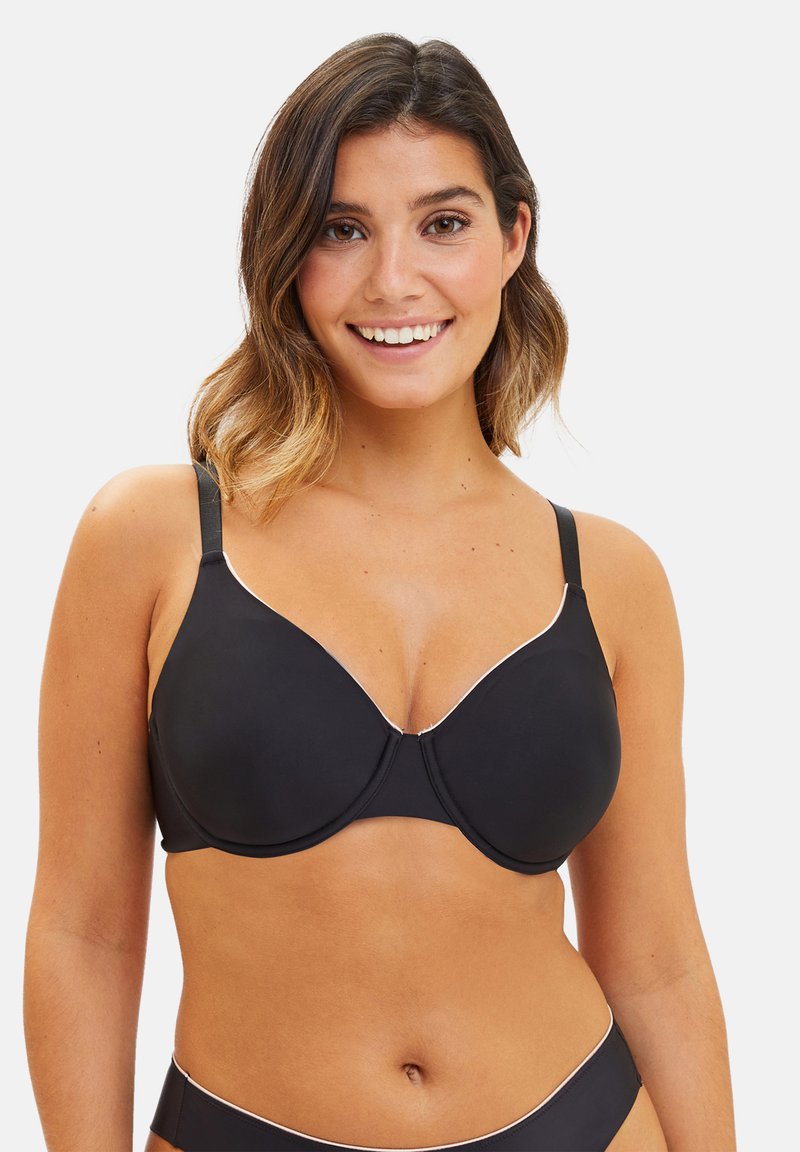 Soutien-gorge noir rembourré avec bord blanc, tissu lisse, bretelles ajustables et décolleté plongeant. Comprend un anneau pour un meilleur maintien.