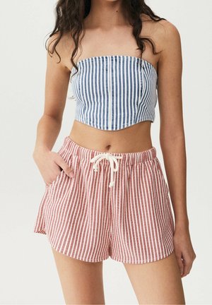 Haut court sans bretelles à rayures bleues et blanches associé à un short à rayures rouges et blanches avec une taille élastique et des poches avant.