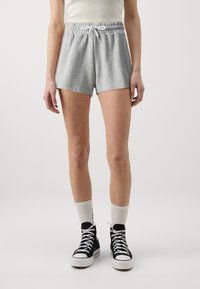 Gray cotton shorts with an elastic waistband and drawstring. Worn with black high-top sneakers and white crew socks.
