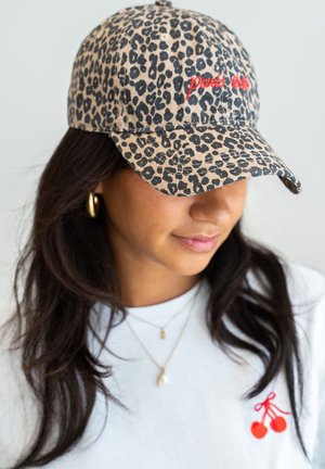 Leopard print baseball cap in tan and black, featuring red embroidered text. Soft fabric with a curved brim and adjustable strap.