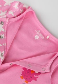 Rosa Baumwollbody mit Sternenmuster, ausgestattet mit Druckknöpfen. Illustratives Eulendesign auf der Vorderseite. Weiche Textur, geeignet für Säuglinge.