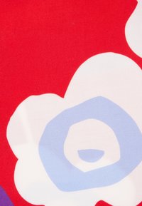 Roter Stoff mit großen weißen und hellblauen Blumenmustern. Glatte Textur, mit kreisförmigen Formen und wellenförmigen Kanten.