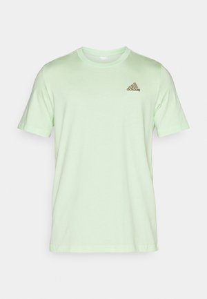 Camiseta de manga corta verde claro hecha de tela suave, con un pequeño logo marrón de Adidas en el lado izquierdo del pecho.