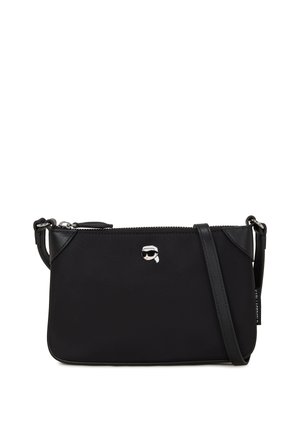 Zwarte crossbody tas van glad materiaal. Heeft een ritssluiting, een zilveren logo accent en een verstelbare schouderband. Compact rechthoekige vorm.