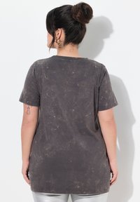 Mørkegrå oversized t-shirt med en tekstureret, slidt fremtoning. Korte ærmer og rund halsudskæring, lavet af blødt bomuldsstof.