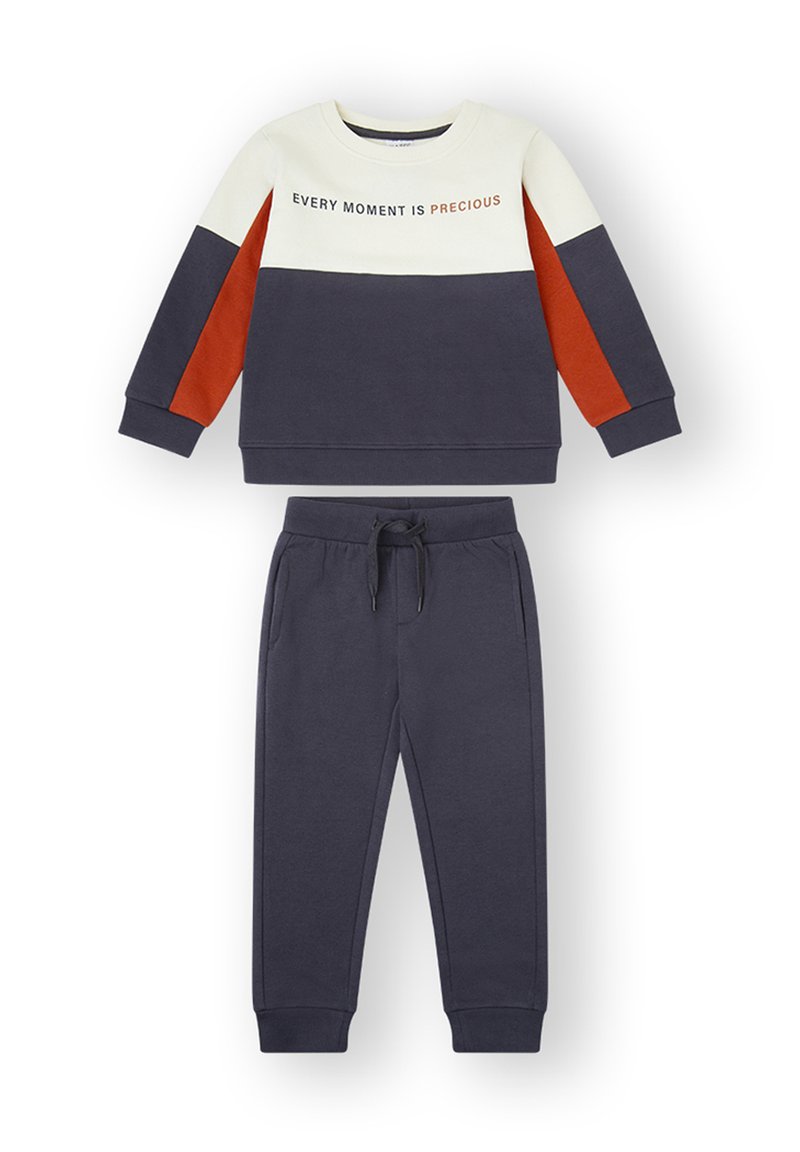 Sudadera azul marino y crema con detalles en naranja, con el texto "CADA MOMENTO ES PRECIOSO." Combinada con pantalones de chándal azul marino a juego. Mezcla suave de algodón.