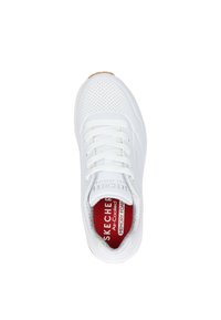Zapatilla deportiva blanca con diseño perforado, punta redonda, cordones planos y plantilla roja etiquetada como "Espuma de Memoria Refrescante". Suela de goma marrón claro.