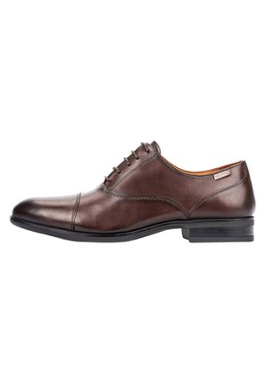 Zapato de vestir de cuero marrón con puntera redondeada, diseño de cordones y suela negra elegante. Costuras notables a lo largo de la parte superior y un logotipo minimalista.