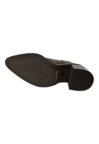 Zapato de tacón de cuero marrón con punta afilada, superficie texturizada y suela de goma. Presenta patrones sutiles y un tacón robusto en bloque.