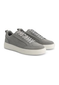 Grijze suède sneakers met een witte rubberen zool, voorzien van ronde veters, een textuur oppervlak en een lage instap. Geaccentueerd met zijstiksels.