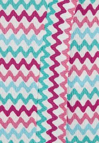 Tela de patrones zigzagueantes multicolores que presenta tonos de verde azulado, rosa y blanco. La textura es suave, con un diseño de superficie ondulado y peludo.