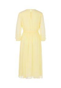Gelbes Chiffonkleid mit langen Ärmeln, taillierter Taille und rüschierten Manschetten. Besitzt eine Aussparung am Rücken. Knielange Länge.