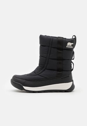 Botte d'hiver noire isolante avec semelle texturée, étiquette imperméable et logo Sorel sur la partie supérieure rembourrée, vue de côté.