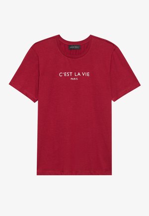 Crvena pamučna majica s kratkim rukavima i okruglim izrezom. Na prednjoj strani ima otisnut bijeli tekst "C'EST LA VIE PARIS". Glatka tekstura.
