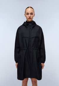 Zwarte lichte regenjas met een ritssluiting aan de voorkant, een capuchon met trekkoord, een elastische taille en zakken. Heeft een gladde textuur en een relaxte pasvorm.