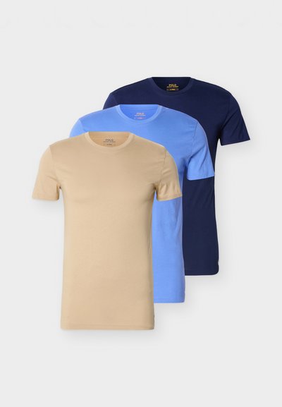 Τρία μπλουζάκια σε σετ, σε μπεζ, ανοιχτό μπλε και ναυτικό μπλε χρώμα. Κάθε ένα έχει στρογγυλή λαιμόκοψη και κοντά μανίκια, κατασκευασμένα από απαλό ύφασμα.