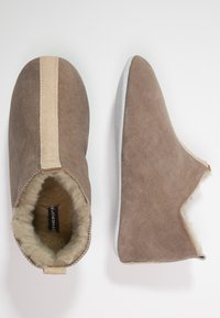 Brown suede slip-on shoes with a soft interior lining. Features a tan accent stripe and a flexible light gray outsole.