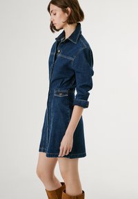 Denim shirt dress in dark blue, featuring a button-down front, long sleeves, and a fitted waist with a flared hem.ó