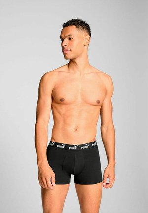 Black boxer briefs with a fitted design and elastic waistband featuring the Puma logo. Smooth fabric texture and mid-thigh length.
