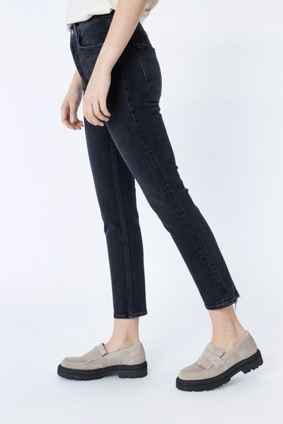 Zwarte slim-fit jeans met een rafelige zoom. Gepaard met beige suède loafers met een rubberen zool en franjes.