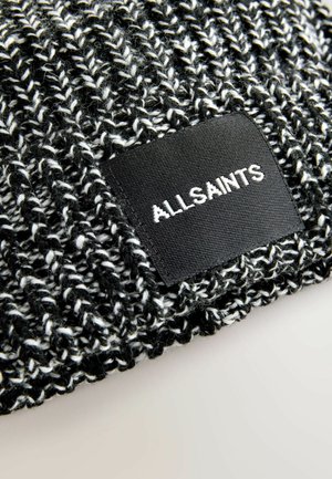 Černá a bílá pletená čepice s texturovaným vzorem. Obsahuje obdélníkovou černou etiketu s nápisem "ALLSAINTS" v bílé barvě.